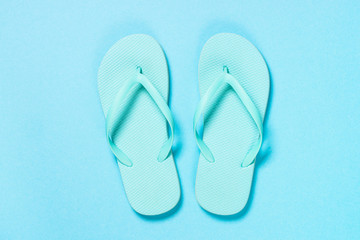 Blue flip flops on blue background.
