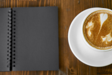 Cup of hot coffee latte on a wooden table