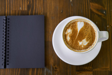 Cup of hot coffee latte on a wooden table