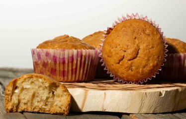 homemade muffins with coconut chips on a wooden stand