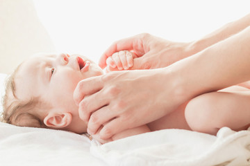 Baby and hands of a mother, indoors, blurred background