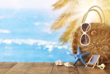 vacation and summer concept with sea life style objects over wooden table infront of sea landscape background