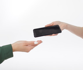 female hand passes the other hand the phone. hands with a phone on a white background. buying a...