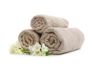 Clean rolled towels with flowers on white background