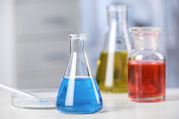 Laboratory glassware with samples on table indoors. Solution chemistry