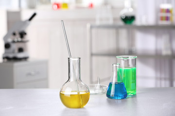 Laboratory glassware with samples on table indoors, space for text. Solution chemistry