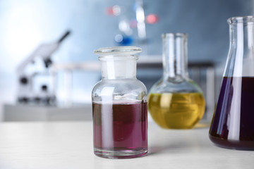 Laboratory glassware with samples on table indoors, space for text. Solution chemistry
