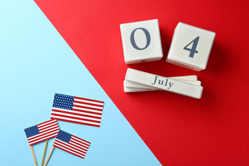 Flat lay composition with wooden calendar and USA flags on color background. Happy Independence Day