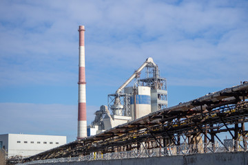 Fototapeta na wymiar Plant for the production of cement. Industrial zone. Industrial buildings and chimney pipes.