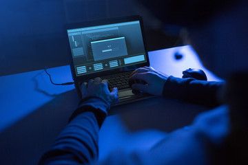 cybercrime, hacking and technology concept - hands of hacker with progress loading bar on laptop computer screen making cyber attack in dark room