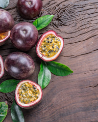 Passion fruits and its cross section with pulpy juice filled with seeds. Wooden background.