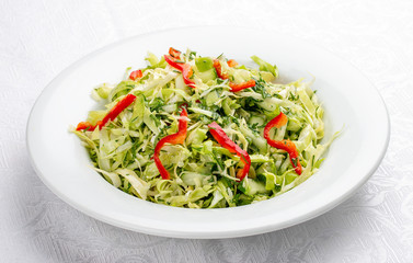 Salad with fresh cabbage and cucumber. On white background