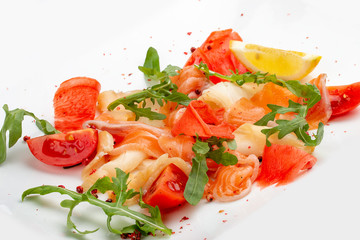 Sliced fish, salmon and perch with arugula and tomatoes. On white background