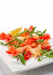 Sliced fish, salmon and perch with arugula and tomatoes. On white background