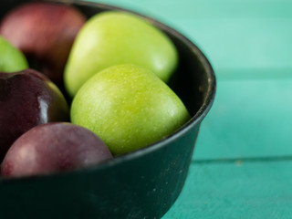 Apples in an vintage iron plate on a wooden background. Side view