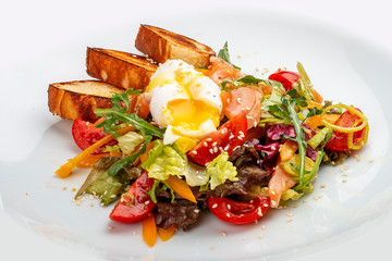 Poached egg with croutons and vegetable salad on white background