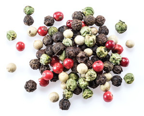 Black, white, green and red peppercorns isolated on white background.