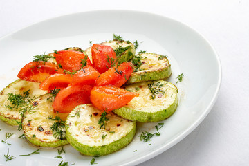 Grilled zucchini with tomatoes on white background