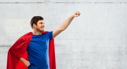 super power and people concept - happy young man in red superhero cape over grey concrete background