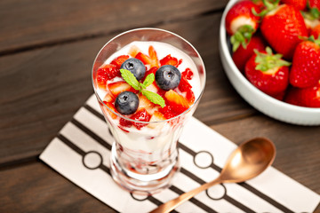 Healthy sweet dessert in glass with strawberries, yogurt and blueberries