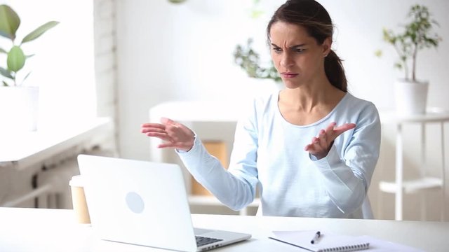 Angry stressed young businesswoman feeling mad using stuck computer