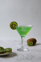 Refreshing kiwi lemonade with ice on a light background