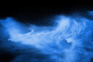 Blue powder explode cloud on black background. Launched blue dust particles splash.