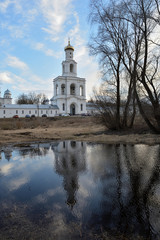 Fototapeta na wymiar Spring view of the Yurievsky Monastery with reflection in the water. Great Novgorod