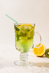Refreshing lemonade from kiwi and lemon on a light background. Vertical orientation