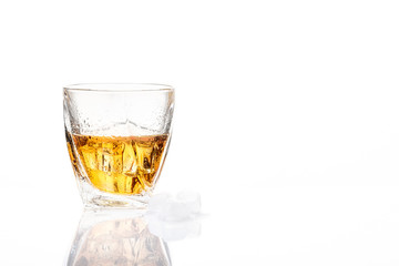 The glass of whisky on white background. Side view. Blank space.