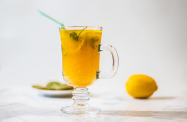 Freshly squeezed orange juice with pulp, kiwi and lemon on a light background. Horizontal orientation