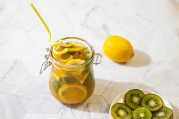 Freshly squeezed orange juice with pulp, kiwi and lemon on a light background. Horizontal orientation