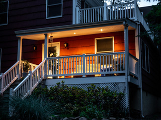 red suburban house front facade and patio at dusk