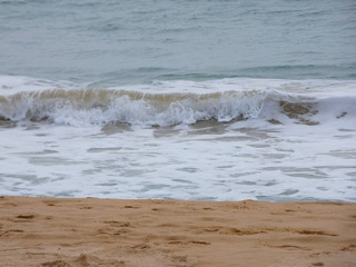 Olas llegando a la arena de la playa en un día de tormenta primaveral