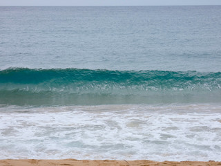 Olas llegando a la arena de la playa en un día de tormenta primaveral