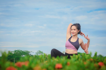 Young Asian woman practicing yoga in the park