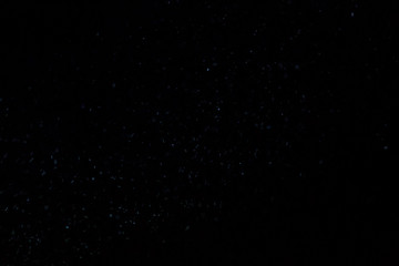 Abstract real dust floating over black background