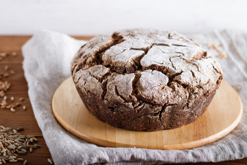 Yeast free homemade bread with whole rye and wheat grains on rustic wooden background.