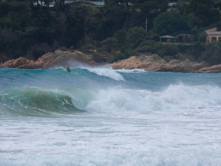 Obraz na płótnie Canvas Olas rompiendo en la playa y surfistas esperando la Ola para cabalgarla
