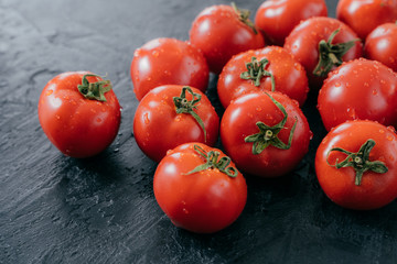 Horizontal shot of red fresh tomatoes harvested for making vegetable salad. Healthy eating and vitamins concept. Juicy organic tomatos