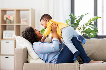 childhood, kids and people concept - happy african american mother with her baby son at home