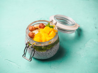 Chia seed pudding in jar with coconut milk, mango and nuts