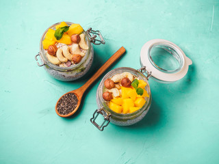Chia seed pudding in jar with coconut milk, mango and nuts
