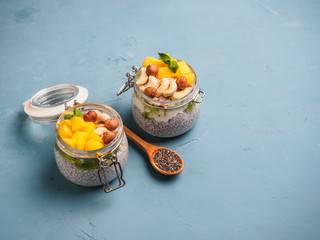 Chia seed pudding in jar with coconut milk, mango and nuts