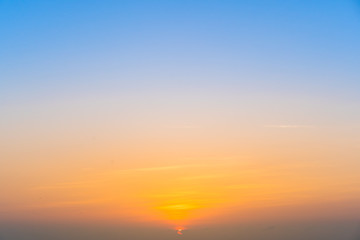 Beautiful the sunrise near the sky line, beautiful sky in blue and warm tone during the sunrise.  Sunrise background.