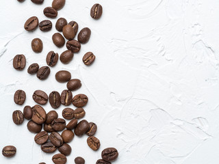 Coffee beans with copy space. Brown coffee beans on white concrete textured background. Top view or flat lay. Copy space.