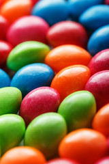 Rainbow colors of multicolored candies close-up, texture and repetition of dragee