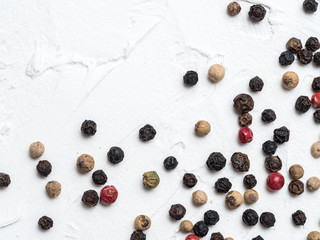 Assorted peppercorns. Medley trio colorful peppercorn on white textured concrete background with copy space. Top view or flat lay.