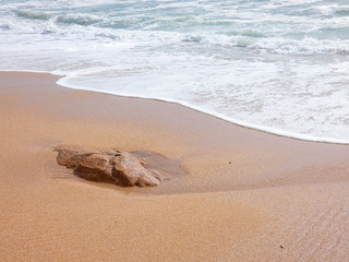 Olas llegando a la playa y dejando una estela de espuma