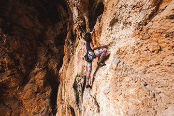 A girl climbs a rock.